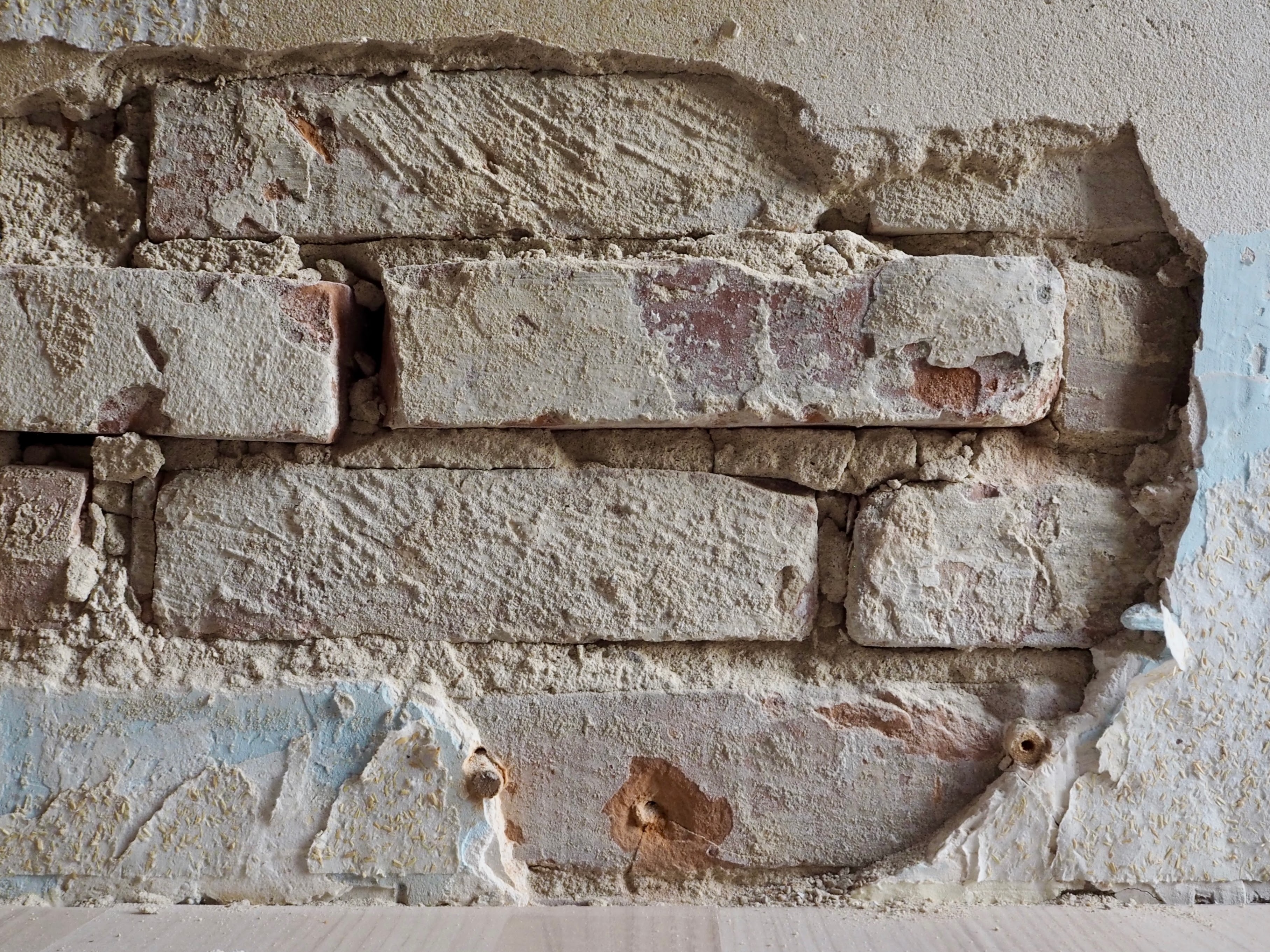From the "this doesn't look good" department: we started removing wallpaper from a wall in the entrance and discovered crumbling plaster hiding shoddy (but of course!) bricklayer work. Sigh! I guess we need to find a mason now.